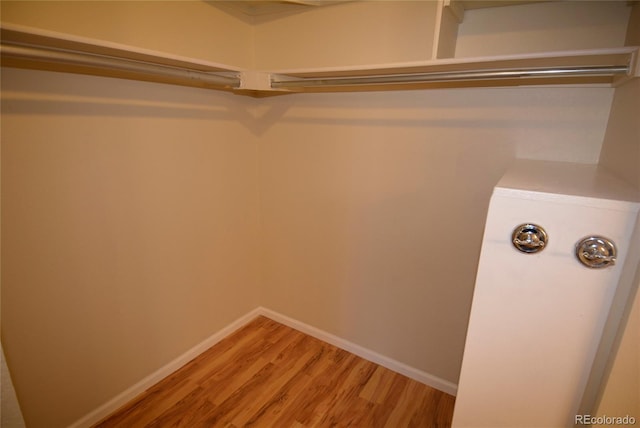 walk in closet with light wood-style flooring