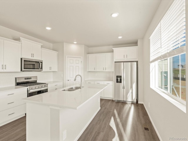 kitchen featuring dark wood-type flooring, sink, an island with sink, white cabinetry, and appliances with stainless steel finishes