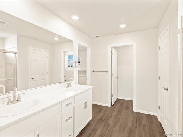 bathroom with hardwood / wood-style floors, vanity, and an enclosed shower