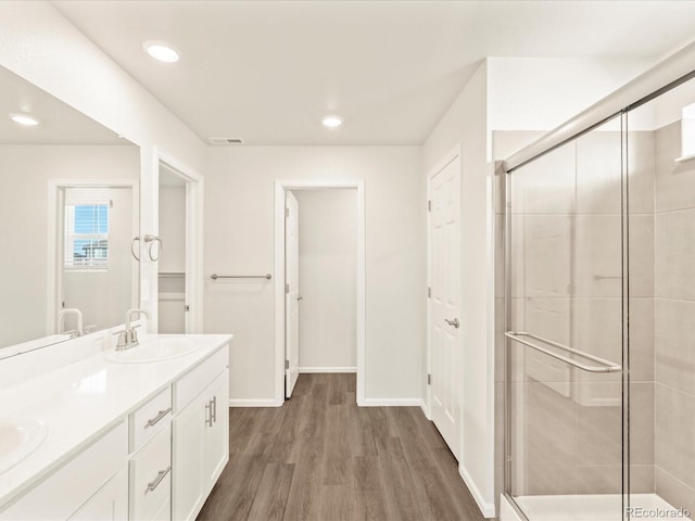 bathroom with vanity, wood-type flooring, and a shower with shower door