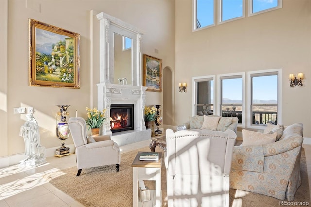 7615 Lemon Gulch Way, Castle Rock, CO 80108 - tiled living room featuring arched walkways, a high end fireplace, and a high ceiling