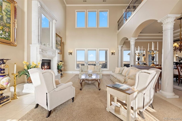 7615 Lemon Gulch Way, Castle Rock, CO 80108 - living room featuring decorative columns, arched walkways, a glass covered fireplace, ornamental molding, and a towering ceiling