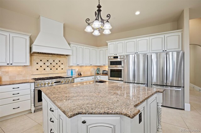 7615 Lemon Gulch Way, Castle Rock, CO 80108 - kitchen featuring appliances with stainless steel finishes, custom range hood, light tile patterned floors, and light stone counters