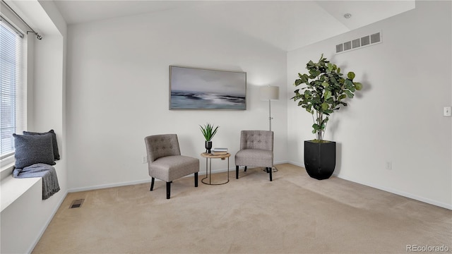 living area with lofted ceiling and light carpet