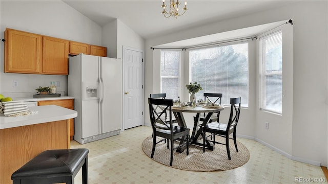 dining space featuring vaulted ceiling and a chandelier