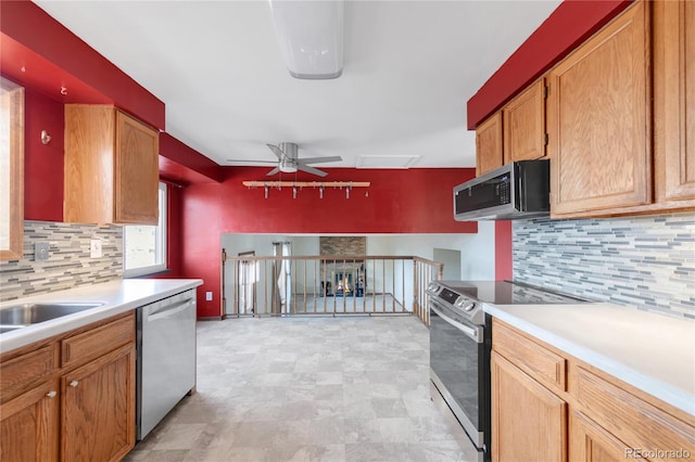 kitchen with decorative backsplash, appliances with stainless steel finishes, light countertops, and a ceiling fan