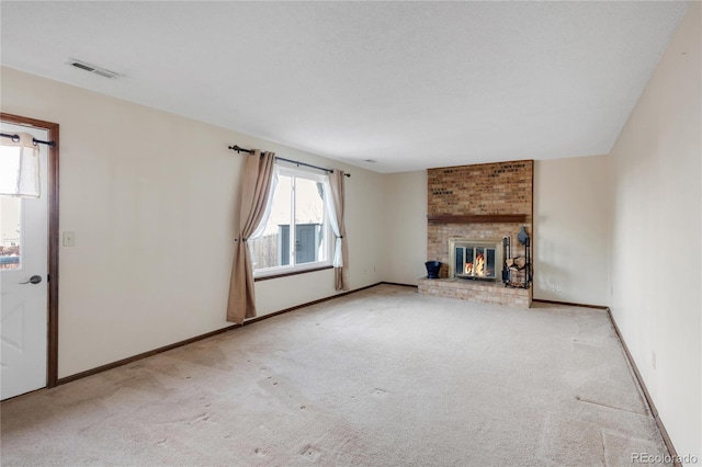 unfurnished living room with visible vents, baseboards, a brick fireplace, and carpet flooring