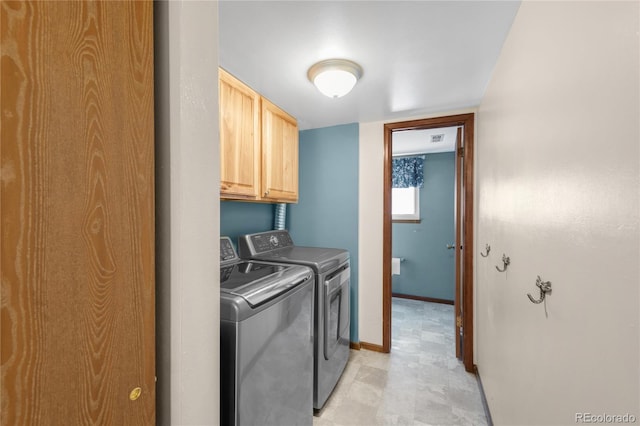 laundry room featuring cabinet space, washer and dryer, light floors, and baseboards