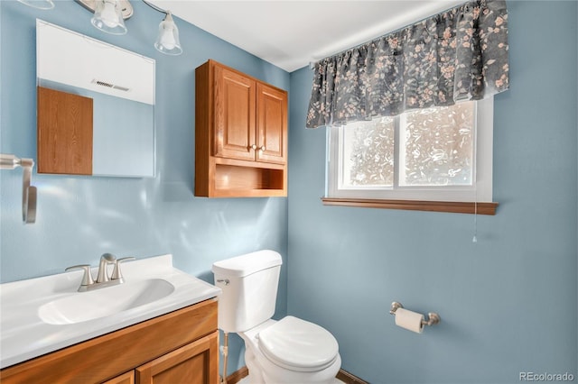 half bathroom with visible vents, toilet, and vanity