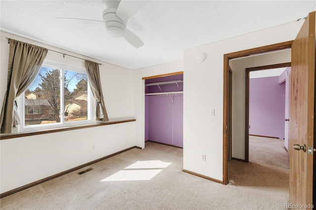 unfurnished bedroom featuring visible vents, carpet, a closet, and a textured ceiling