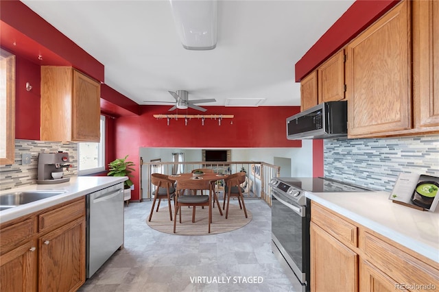 kitchen featuring decorative backsplash, appliances with stainless steel finishes, light countertops, and ceiling fan