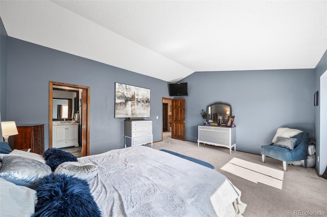 bedroom with carpet, lofted ceiling, and ensuite bath