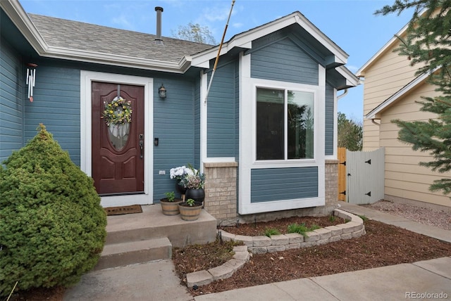 entrance to property with a shingled roof