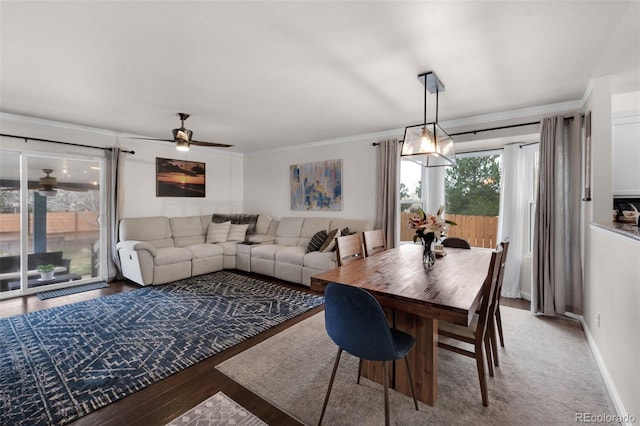 dining room featuring crown molding, wood finished floors, baseboards, and a ceiling fan