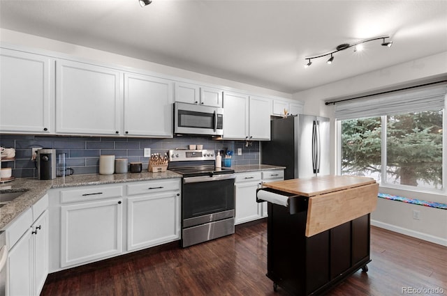 kitchen featuring backsplash, dark wood-style floors, white cabinets, and stainless steel appliances