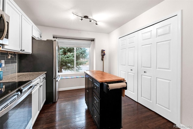 kitchen with stainless steel electric range, wood counters, backsplash, white cabinets, and dark wood-type flooring