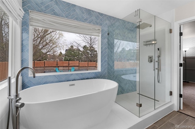 full bathroom with a stall shower, a soaking tub, and tile walls