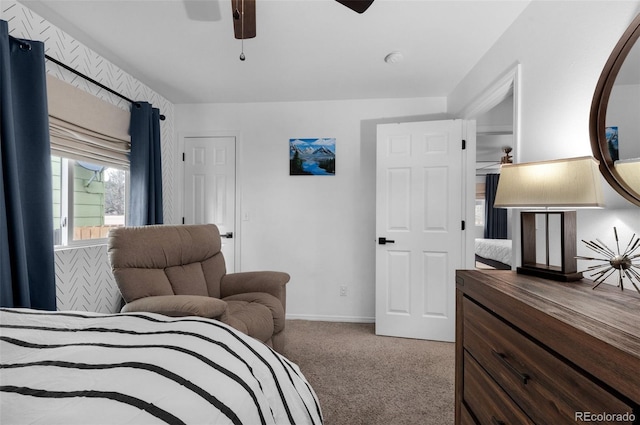 carpeted bedroom featuring baseboards and a ceiling fan