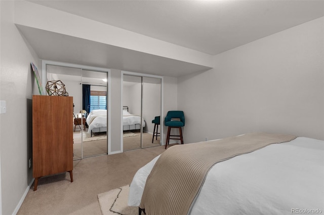 bedroom with carpet, baseboards, and multiple closets