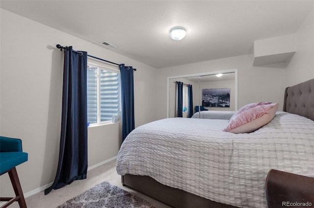 carpeted bedroom featuring baseboards and visible vents