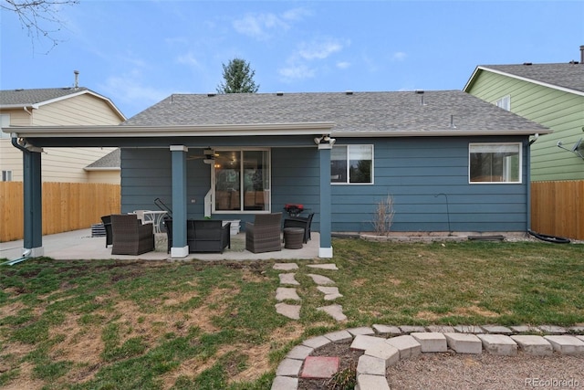 rear view of property with a ceiling fan, a lawn, an outdoor living space, fence, and a patio