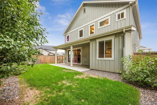 back of property with a yard and a patio