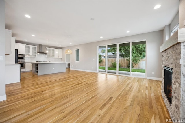 unfurnished living room featuring light wood-type flooring and a fireplace