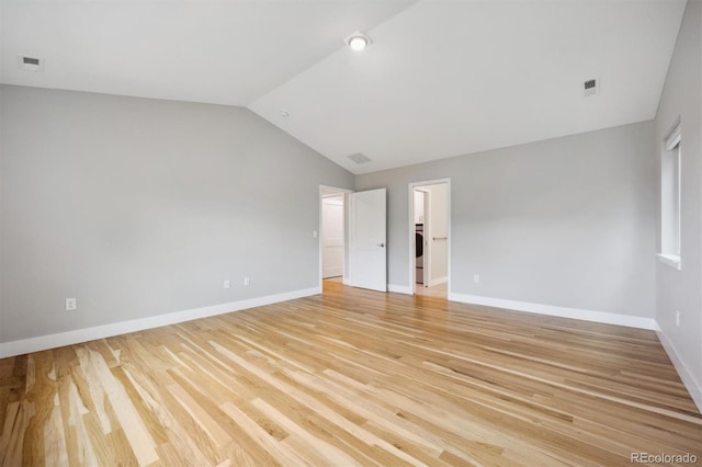 spare room featuring light hardwood / wood-style floors and vaulted ceiling