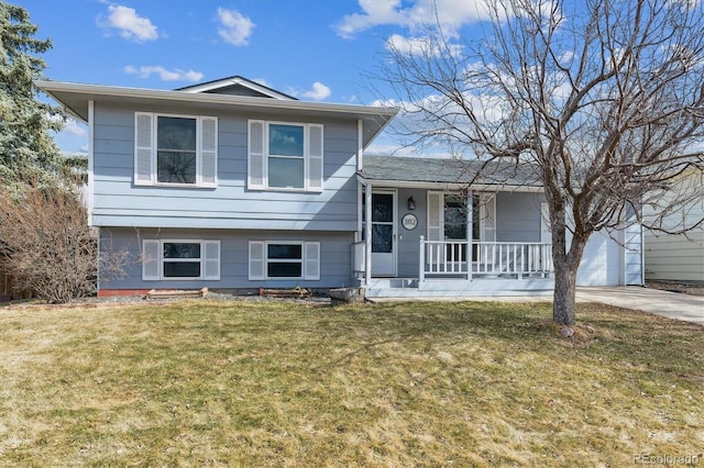 split level home featuring a garage, a front yard, covered porch, and driveway