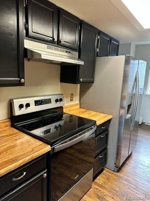 kitchen featuring appliances with stainless steel finishes, light hardwood / wood-style flooring, and butcher block counters