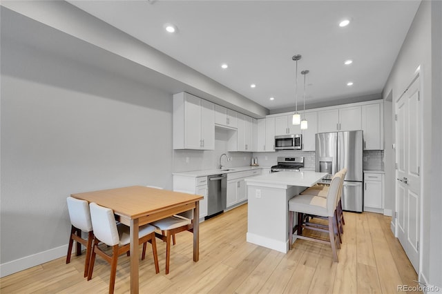 6211 W 28th Ct, Wheat Ridge, CO 80214 - kitchen featuring stainless steel appliances, light countertops, white cabinetry, a kitchen island, and recessed lighting