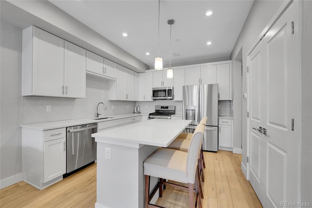 6211 W 28th Ct, Wheat Ridge, CO 80214 - kitchen with appliances with stainless steel finishes, light wood-style floors, white cabinetry, tasteful backsplash, and recessed lighting