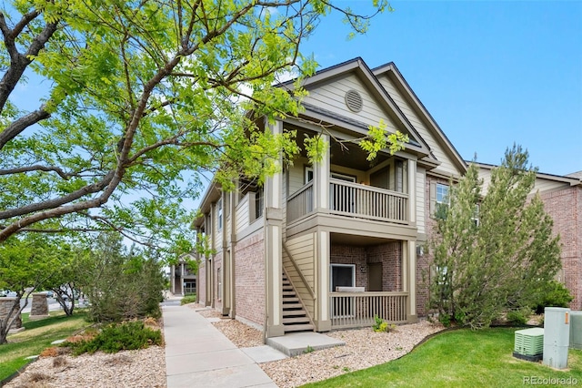 23451 E 5th Dr Unit 203, Aurora, CO 80018 - view of front of home featuring a balcony, brick siding, stairs, and a front lawn