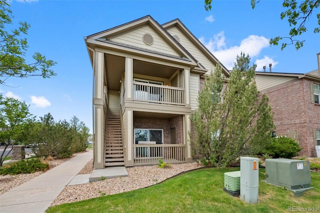 23451 E 5th Dr Unit 203, Aurora, CO 80018 - view of front facade featuring a balcony, a front lawn, and brick siding