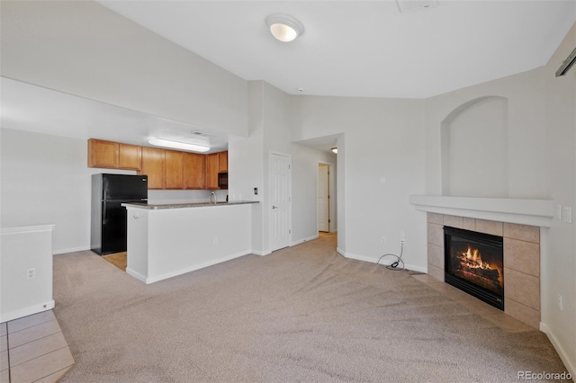 23451 E 5th Dr Unit 203, Aurora, CO 80018 - unfurnished living room featuring light colored carpet, a fireplace, baseboards, and high vaulted ceiling