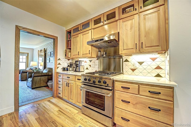 587 21 1/8 Rd, Grand Junction, CO 81507 - kitchen featuring exhaust hood, light wood finished floors, light countertops, high end stove, and backsplash