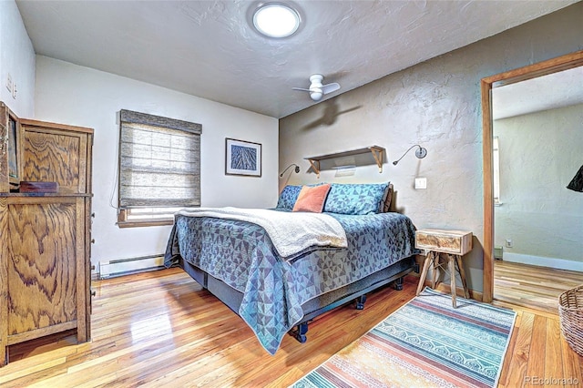 587 21 1/8 Rd, Grand Junction, CO 81507 - bedroom with baseboards, a textured wall, a baseboard heating unit, and wood finished floors