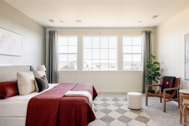 bedroom featuring light carpet and multiple windows