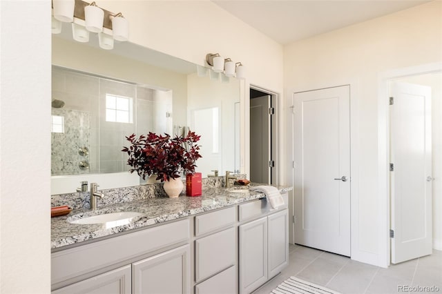 bathroom featuring a tile shower, tile patterned floors, and vanity