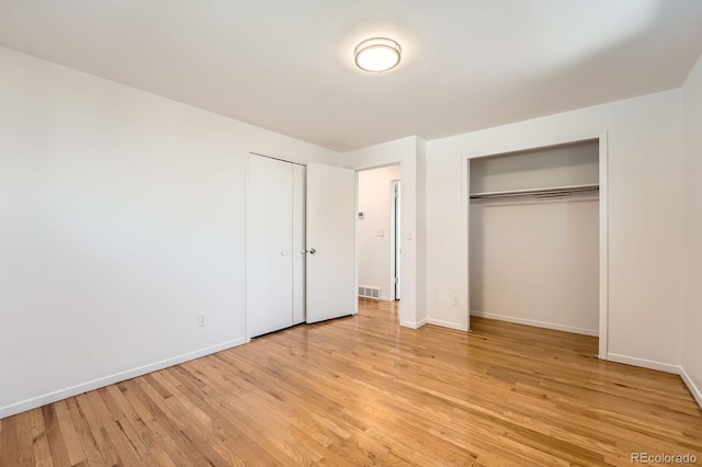 13086 E Alaska Ave, Aurora, CO 80012 - unfurnished bedroom with light wood-type flooring and multiple closets