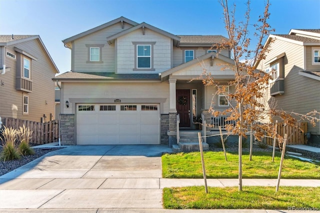 craftsman-style house featuring concrete driveway, stone siding, a porch, fence, and a front lawn