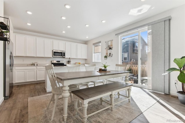 kitchen featuring light wood-style flooring, white cabinetry, stainless steel appliances, and recessed lighting