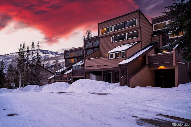 snow covered rear of property with a mountain view