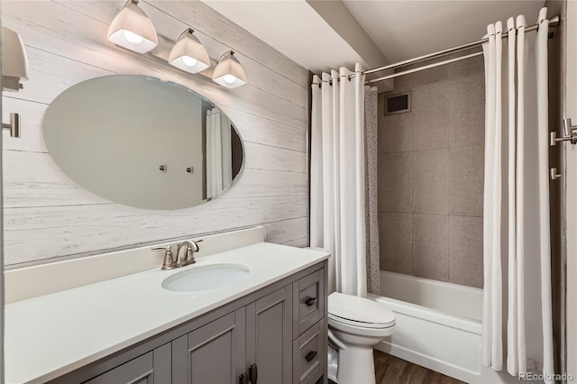 bathroom with wooden walls, visible vents, toilet, shower / bath combo with shower curtain, and vanity