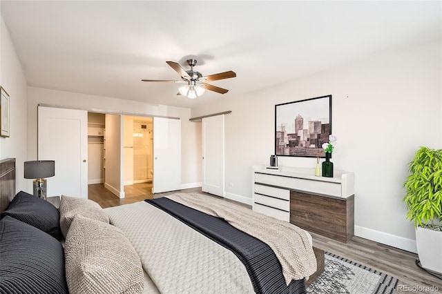 bedroom featuring a ceiling fan, a closet, baseboards, and wood finished floors