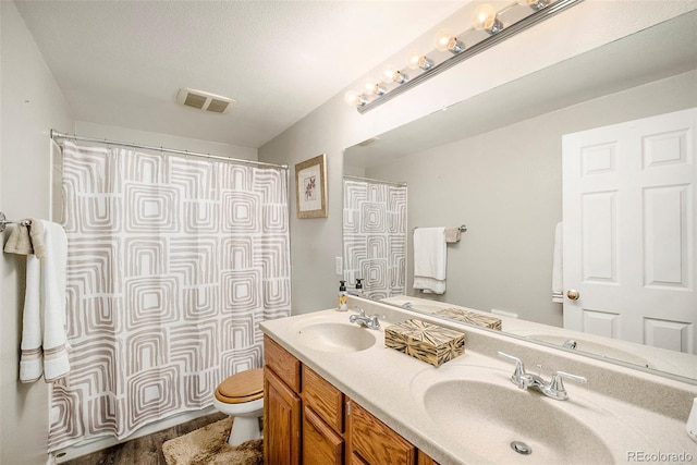 bathroom featuring vanity, wood-type flooring, toilet, and walk in shower