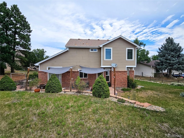 rear view of house with a patio and a yard