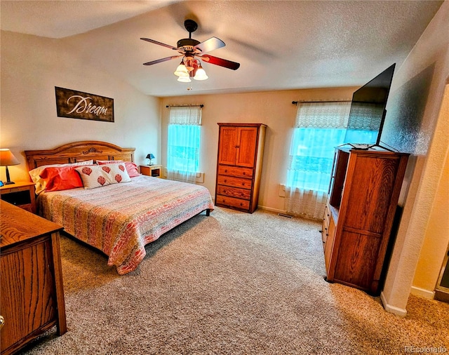 carpeted bedroom featuring vaulted ceiling, a textured ceiling, and ceiling fan