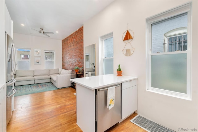 kitchen with visible vents, white cabinetry, a ceiling fan, light countertops, and light wood finished floors