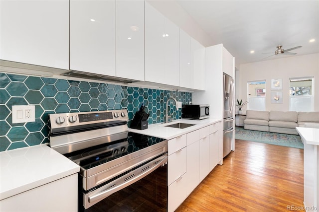 kitchen with appliances with stainless steel finishes, modern cabinets, a sink, and white cabinets